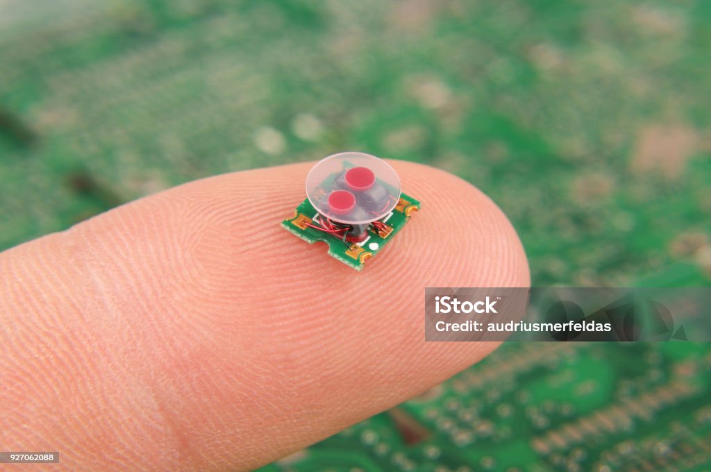 Transformador de RF componente electrónica pequeña en el dedo humano - Foto de stock de Sensor libre de derechos