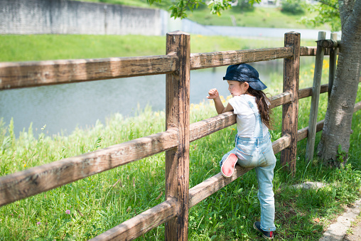 Little girl playing with a fence