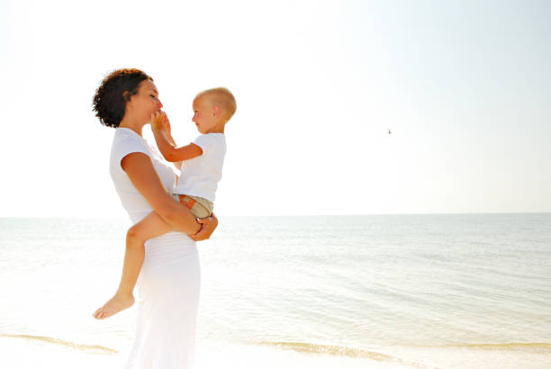 istock Woman holding boy on bich 92706970