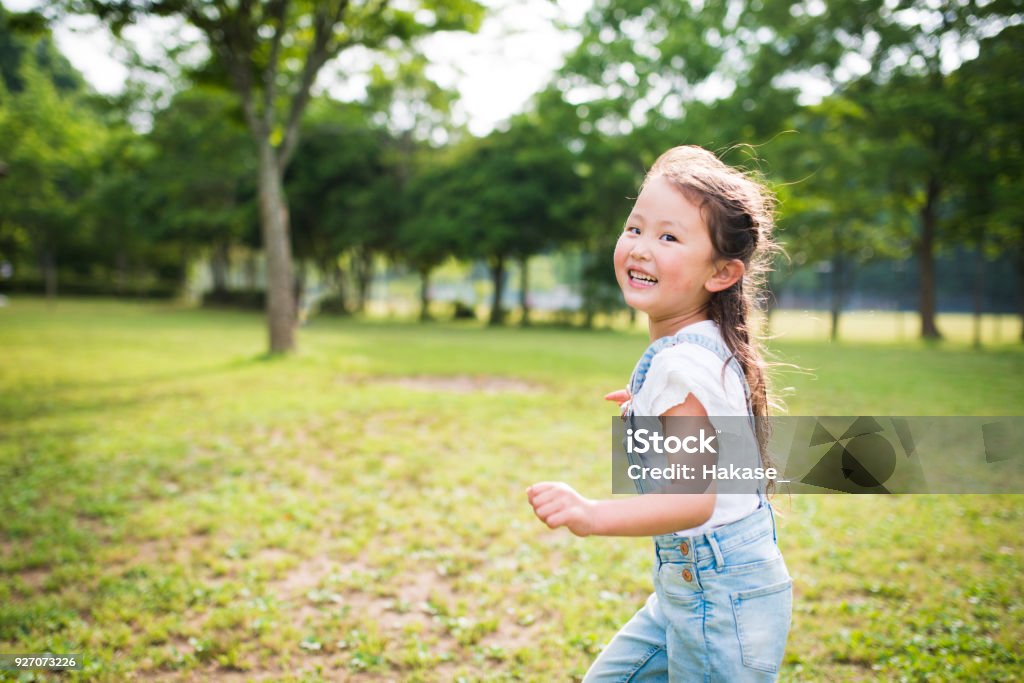 Little girl running while laughing Child Stock Photo