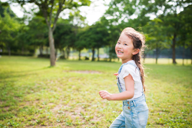Little girl running while laughing Little girl running while laughing girls playing stock pictures, royalty-free photos & images