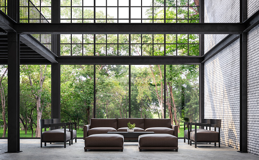 Loft style living room with nature view 3d rendering image.There are white brick wall,polished concrete floor and black steel structure.Furnished with dark brown leather sofa.