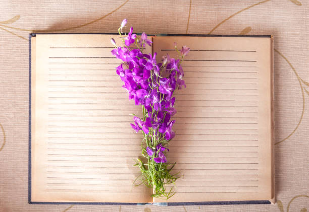 istock Bouquet of lilac flowers on a notebook top view 927076752