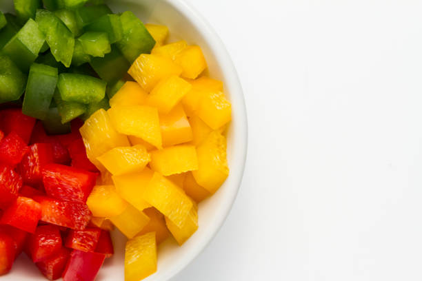 istock Chopped 3 colors Bell pepper in white ceramic bowl 927077610