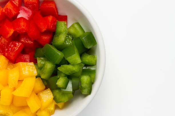 istock Chopped 3 colors Bell pepper in white ceramic bowl 927077618