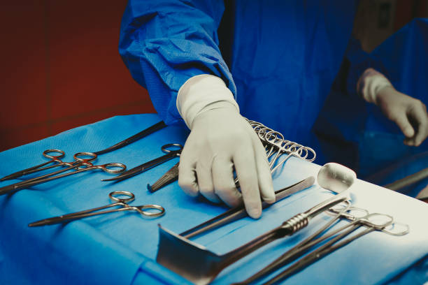 close-up da mão de cirurgiões segurando instrumentos cirúrgicos no centro cirúrgico, instrumentos cirúrgicos sobre a mesa - medical supplies scalpel surgery equipment - fotografias e filmes do acervo