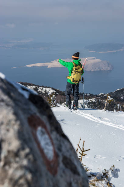 istock Man pointing from mountain top with trail mark on the rock 927084598