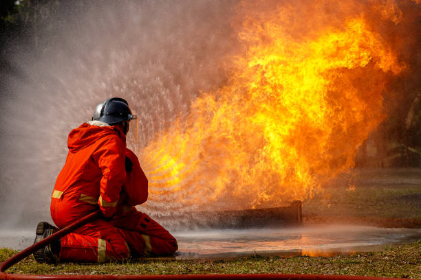 istock Firefighters fighting a fire operation, Water spray by high pressure nozzle to fire surround with smoke, Firefighters extinguish a house 927087240