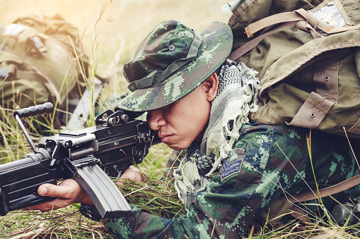 Asian Army soldiers with guns during the military operation in the field, War concept