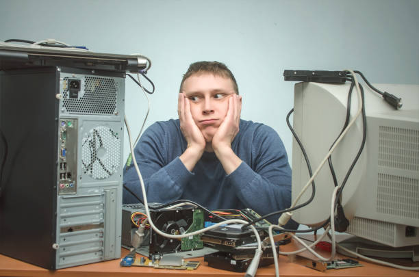 Computer repairman. IT Support. Computer technician engineer man. Support service concept. System administrator. Tired and bored computer repairman is sitting on his workplace and thinking. Computer technician tired from his work and users. PC repair service center. frustrated computer support specialist stock pictures, royalty-free photos & images