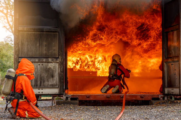 istock Firefighters fighting a fire operation, Water spray by high pressure nozzle to fire surround with smoke, Firefighters extinguish a house 927091116