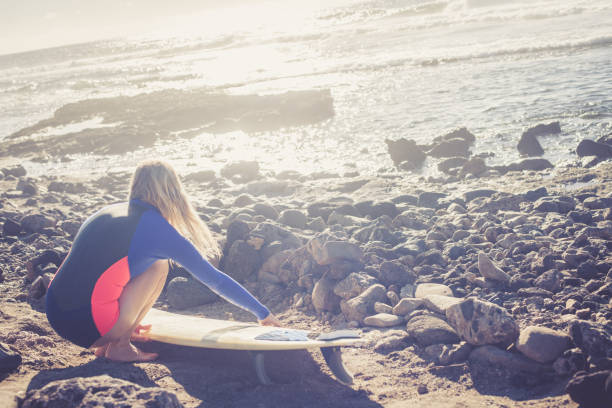 Young female surfer at the beach; Playa Las Americas, Tenerife. Europe / Africa. Nikon D850, All logos removed.