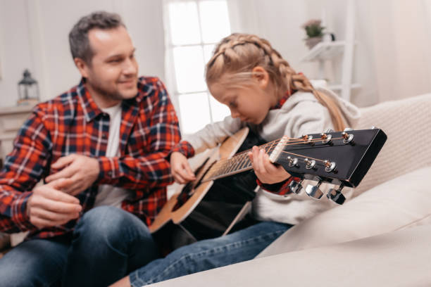istock father and daughter playing guitar 927097904