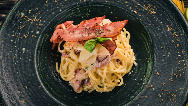 istock Carbonara Paste. Italian cuisine. Top view. On a black wooden background. Copy space. 927101130