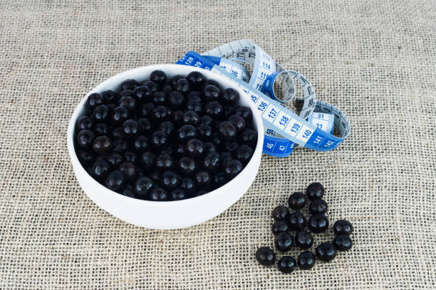 acai berries (euterpe oleracea), native fruit from brazilian amazon and measuring tape - textile healthy eating instrument of measurement tape measure imagens e fotografias de stock