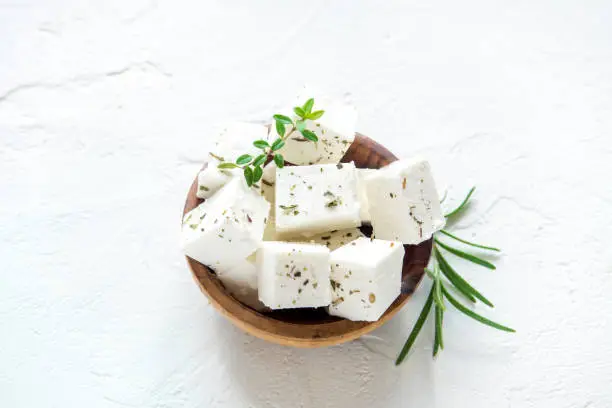 Fresh Greek Feta Cheese. Healthy ingredient for cooking salad. Chopped Goat feta cheese with herbs.