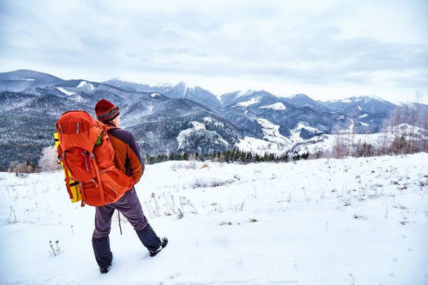 istock Man hiking at sunset mountains with heavy backpack. 927109410