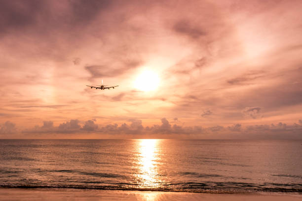 istock Airplane flying to arc sunlight on the sea at evening 927110298