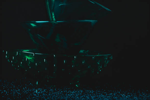 Three green glass bowls with drops and light effect on the table with texture, black background