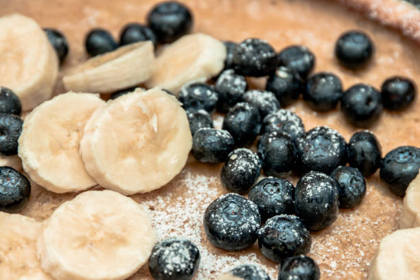 Close-up shot of blueberries, banana and powdered sugar on a pancake