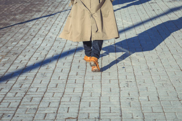 istock a man in yellow shoes walking along the pavement 927145406