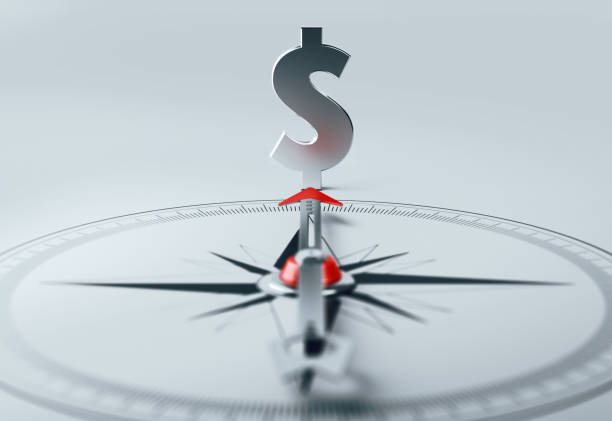 Arrow of compass is pointing American dollar sign. Horizontal composition with selective focus and copy space.