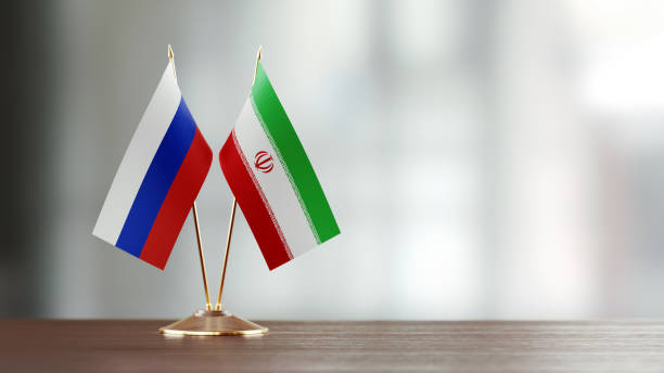 istock Russian And Iranian Flag Pair On A Desk Over Defocused Background 927165254