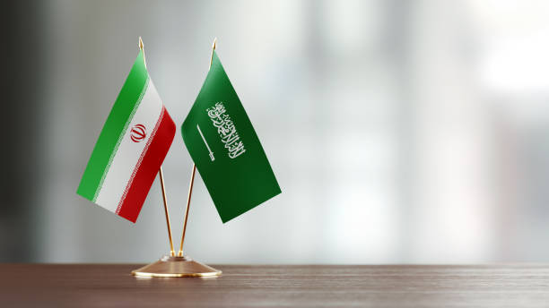 Iranian And Saudi Arabian Flag Pair On A Desk Over Defocused Background Iranian and Saudi Arabian flag pair on desk over defocused background. Horizontal composition with copy space and selective focus. iran stock pictures, royalty-free photos & images