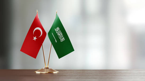 istock Turkish And Saudi Arabian Flag Pair On A Desk Over Defocused Background 927165424