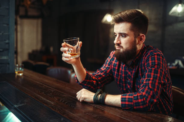 istock Man sitting at the bar counter and drink alcohol 927168634