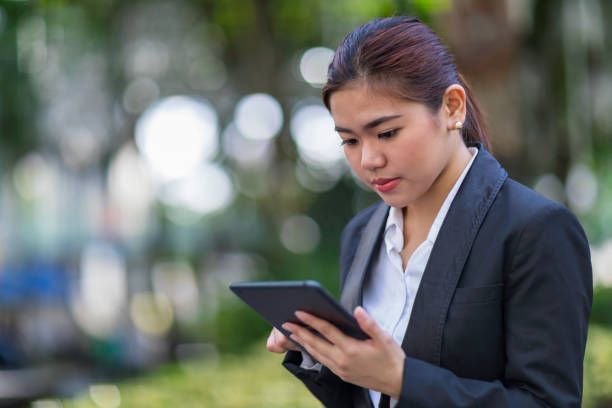 istock Woman typing on a tablet outdoors 927169672