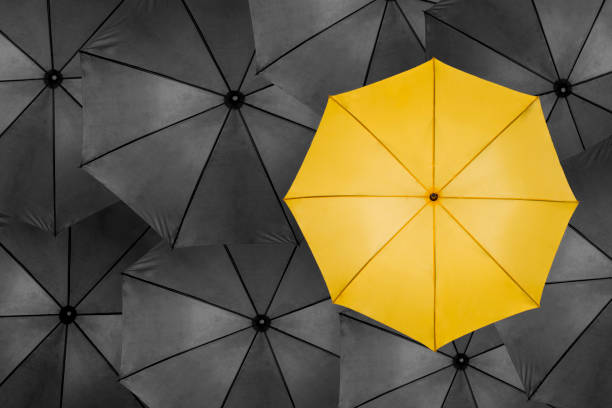 istock Yellow Umbrella with Many Black Ones 927173226