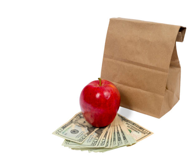 horizontal brown bag with money and red apple - twenty dollar bill us currency currency fanned out imagens e fotografias de stock