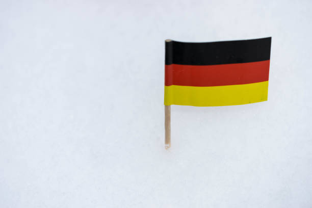 istock Small Germany flag made from paper with brown toothpick on white snow background. 927185150
