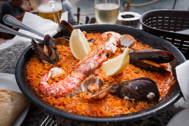 Frying pan with fresh Spanish paella is on the restaurant table. Frying pan with fresh Spanish paella is on the restaurant table. Close up. food state preparation shrimp prepared shrimp stock pictures, royalty-free photos & images