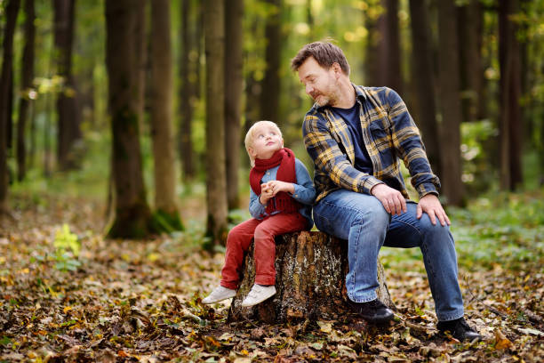 Little boy with his father during stroll in the forest. Active family time on nature. Hike with little kids