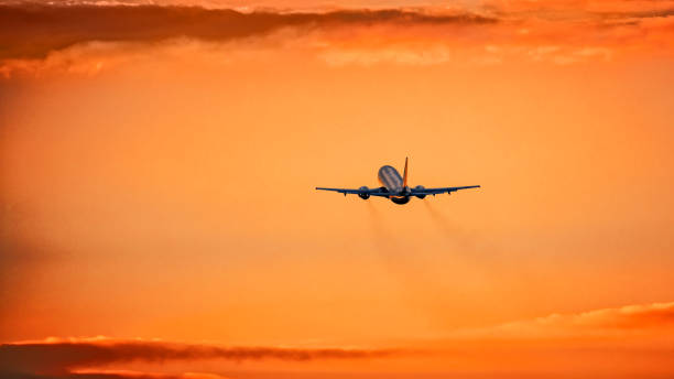 istock Airplane in the air and sunset in background 927191440