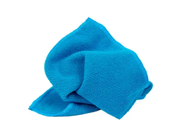 Horizontal shot of a crumpled blue washcloth on a white background.