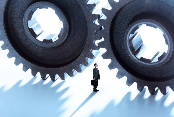 istock Businessman Looks Up At Two Giant Interlocking Gears 927200646