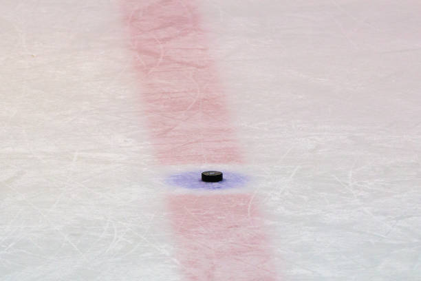 istock Hockey puck on ice stadium 927214084