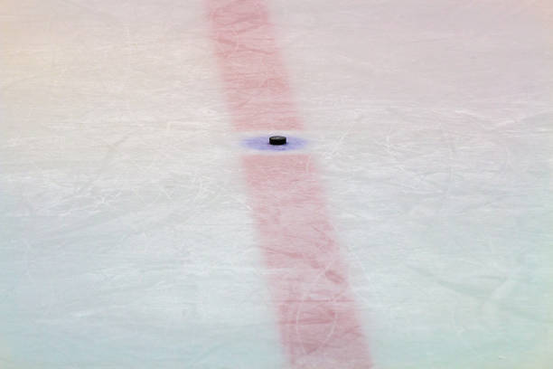 istock Hockey puck on ice stadium 927214110