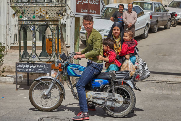 Kashan, Iran - April 27, 2017: A young married couple with two young children went shopping on a motorcycle.