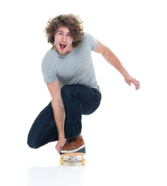 bonito macho jovem em skate e patinação - kneeling skateboarding skateboard vertical - fotografias e filmes do acervo