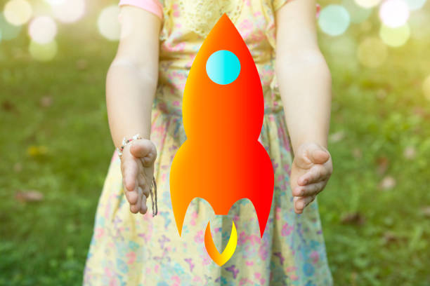 istock Child holding a rocket drawing as startup concept outdoors on a sunny day 927215278