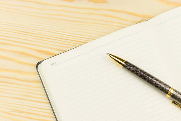 istock Notepad with pen  on wooden background 927226010