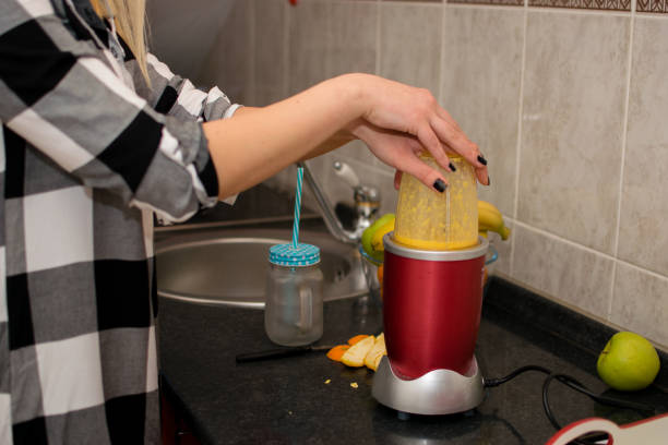 istock Young woman making orange juice in her kitchen 927241196