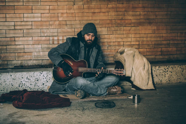 istock Homeless musician playing guitar 927252820