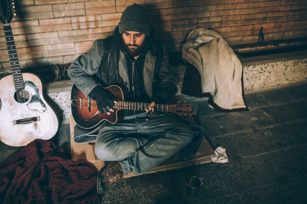 istock Homeless man playing guitar 927252880