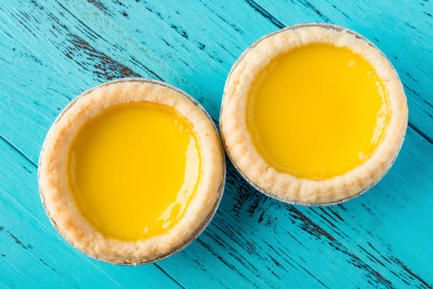 sesión de estudio de la vista superior de dos tartas de huevo sobre un fondo de madera - egg tart fotografías e imágenes de stock