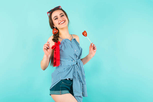 istock Young woman with heart-shaped lollipops 927256800